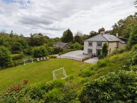 A house with lawn and chairs at Cwmalis Hall in Llangollen