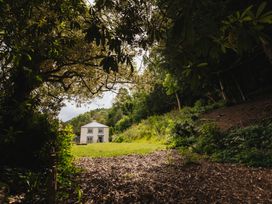 A house in a garden surrounded by trees at Cwmalis Hall Llangollen