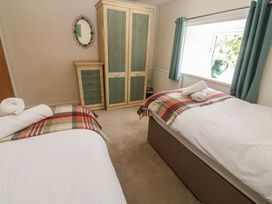 A bedroom with two beds and a wardrobe at Meadowside in Mousehole