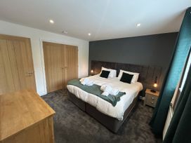 A bedroom with a bed and wardrobe at Willow, Retallack near St Columb Major