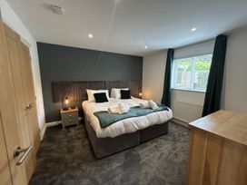 A bedroom with a bed and two nightstands at Willow, Retallack near St Columb Major