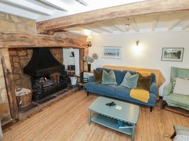 A living room with a fireplace and a sofa at Priors Mead in Claydon near Cropredy