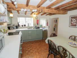 A kitchen with a dining table and appliances at Priors Mead in Claydon near Cropredy