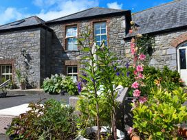A stone building with plants and seating area at Coach House Kilbeg near Borris-In-Ossory County Laois