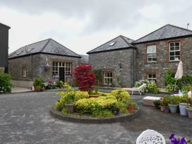 A courtyard with buildings and flower arrangements at Coach House in Kilbeg near Borris-In-Ossory, County Laois