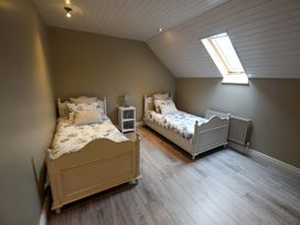 A bedroom with two beds and a bedside table at Coach House Kilbeg near Borris-In-Ossory, County Laois