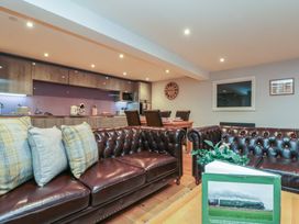 A living room with sofas and a kitchen area at Tornado @ Engine Shed in Whitby