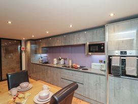 A kitchen with appliances and dining setup at Tornado @ Engine Shed Whitby