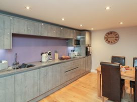 A kitchen with cabinets and a dining area at Tornado @ Engine Shed in Whitby