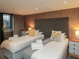 A bedroom with two beds and a bedside table at Tornado @ Engine Shed in Whitby