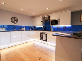 A kitchen with modern appliances and a clock at Blue Peter @ Engine Shed Whitby