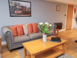 A living room with a sofa, coffee table, and a vase of flowers at Olton Hall @ Engine Shed in Whitby