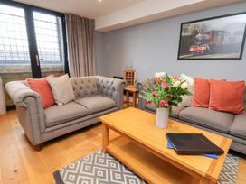 A living room with a sofa, table, and floral arrangement at Olton Hall @ Engine Shed, Whitby