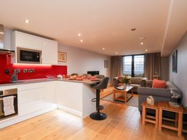 A living room with a sofa, coffee table, and kitchen unit at Olton Hall @ Engine Shed Whitby