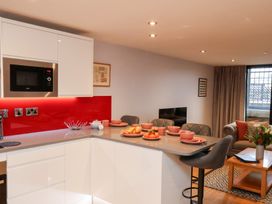 A kitchen with a bar counter and dining plates at Olton Hall @ Engine Shed Whitby