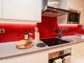 A kitchen with a countertop featuring bread, wine, and utensils at Olton Hall @ Engine Shed in Whitby