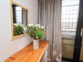 A corner with a mirror and a flower arrangement on a sideboard at Olton Hall @ Engine Shed, Whitby
