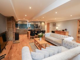 A living room with a sofa and kitchen area at Mallard @ Engine Shed in Whitby