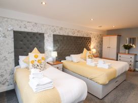 A bedroom with two beds and a wardrobe at Mallard @ Engine Shed in Whitby