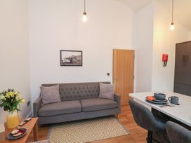 A living room with a sofa and dining table at Evening Star @ Engine Shed in Whitby