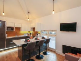 A kitchen with stools and appliances at Evening Star @ Engine Shed in Whitby