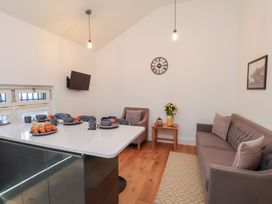 A living room with a sofa, table, and television at Evening Star @ Engine Shed Whitby