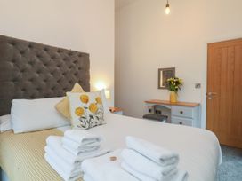 A bedroom with a bed, desk, and flowers at Evening Star @ Engine Shed in Whitby