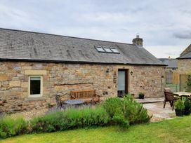 An outdoor area with seating and plants at Hemmel Cottage in Chatton