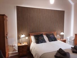 A bedroom with a bed and wardrobe at Hemmel Cottage in Chatton