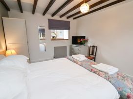 A bedroom with a bed and television at Mill House in Robin Hood's Bay