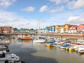A marina with boats and colorful buildings at Meadow View Cottage in Lympstone