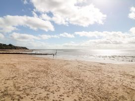 A beach with sand and ocean at Meadow View Cottage in Lympstone