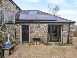 An outdoor view of a stone cottage with solar panels at Lazy Hare at Jen's Orchard St Giles On The Heath