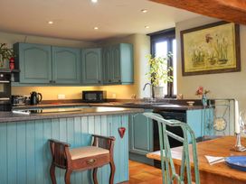 A kitchen with cabinets and appliances at Lazy Hare at Jen's Orchard in St Giles On The Heath