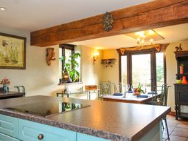 A kitchen with a stove and dining area at Lazy Hare at Jen's Orchard St Giles On The Heath