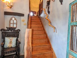 An entrance area with stairs and a chair at Lazy Hare at Jen's Orchard St Giles On The Heath