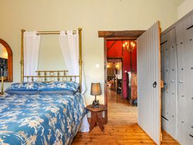 A bedroom with a bed and a wardrobe at Lazy Hare at Jen's Orchard St Giles On The Heath