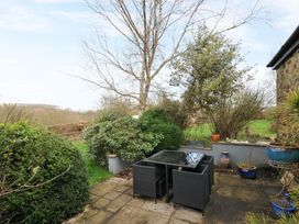 A garden with a table and chairs at Lazy Hare at Jen's Orchard St Giles On The Heath