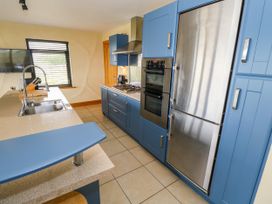 A kitchen with blue cabinets and stainless steel appliances at Ocean Sail House Termon near Dungloe County Donegal