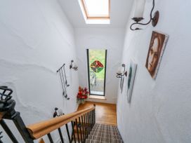 A staircase leading to a window with flower arrangement at Ocean Sail House Termon near Dungloe, County Donegal