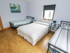 A bedroom with a double bed and two single beds at Ocean Sail House in Termon near Dungloe, County Donegal