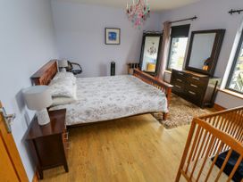 A bedroom with a bed, dresser, and window at Ocean Sail House in Termon near Dungloe, County Donegal