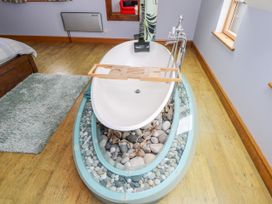 A bathtub with rocks and a wooden tray at Ocean Sail House Termon near Dungloe County Donegal