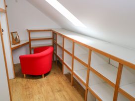 A study with a red chair and shelves at Ocean Sail House in Termon near Dungloe, County Donegal