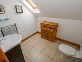 A bathroom with a sink, toilet, and storage cabinet at Ocean Sail House, Termon near Dungloe, County Donegal