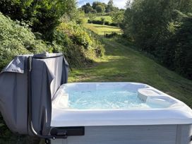 A hot tub with cover near a pathway at Lower Norton Farmhouse in Dartmouth