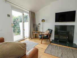 A living room with a fireplace and television at Bwthyn in Moelfre