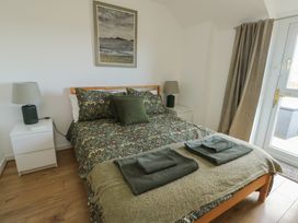 A bedroom with a bed and bedside table at Bwthyn in Moelfre