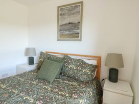 A bedroom with a bed and bedside tables at Bwthyn in Moelfre