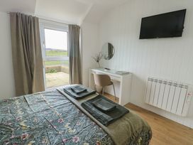 A bedroom with a bed and desk at Bwthyn in Moelfre